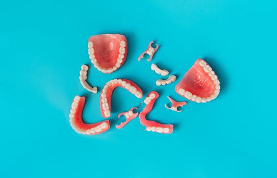 Several types of dentures laid out on blue background