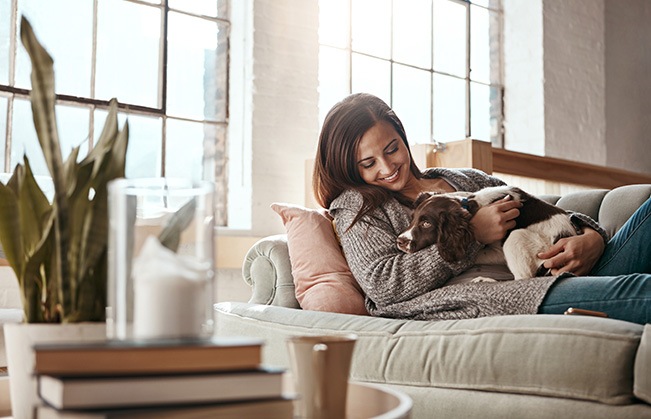 Woman relaxing on couch with her dog