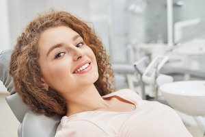 Woman leaning back in dental chair smiling